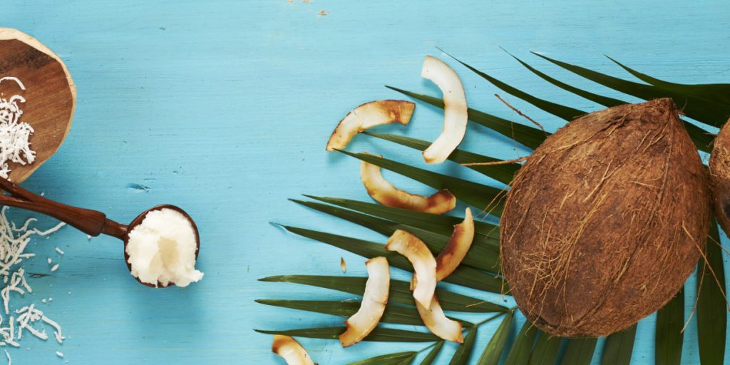 Coconut milk, whole coconuts, coconut oil, and toasted coconut, studio shot on turquoise background